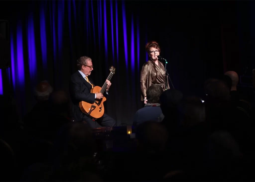 Martin Taylor playing a guitar and Alison Burns singing at the Port Erin Jazz Festival.